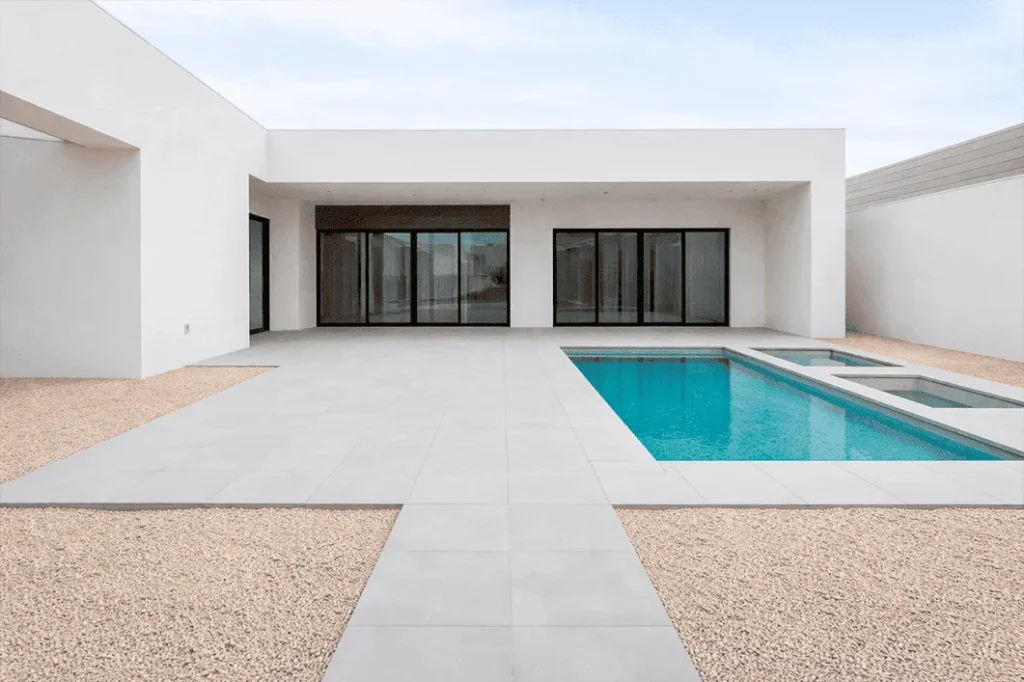 Área externa com piscina sem paisagismo: piso e faixas de cascalho, sem canteiros ou vegetação